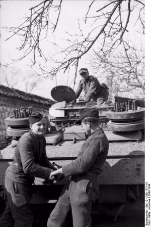 Nordfrankreich.- Soldaten vor und auf Sturmgeschütz III; PK 698 — Frankreich-Nord — Die beiden Soldaten werfen den Motor mit der Handkurbel an.