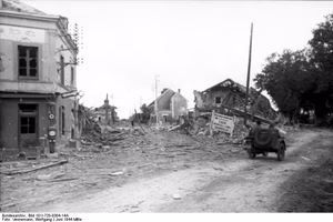 Frankreich, bei Falaise.- zerstörte Gebäude in Ortschaft. Krad mit Beiwagen Wegweiser "Caen, Bagnoles de l'Orne, Granville" passierend; KBZ Ob. West — Frankreich