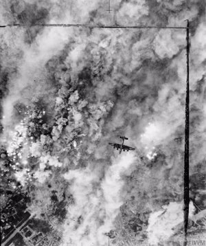 Royal Air Force Bomber Command, 1942-1945. A Handley Page Halifax of No. 4 Group flies over the suburbs of Caen, France, during a major daylight raid to assist the Normandy land battle during Operation CHARNWOOD. 467 aircraft took part in the attack, which was originally intended to have bombed German strongpoints north of Caen, but the bombing area was eventually shifted nearer the city because of the proximity of Allied troops to the original targets. The resulting bombing devastated the northern suburbs.