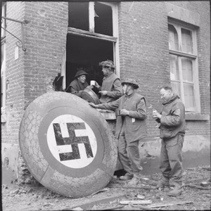 The British Army in North-west Europe 1944-45 Troops stop for tea in Kranenberg, next to a large circular swastika emblem, 9 February 1945.