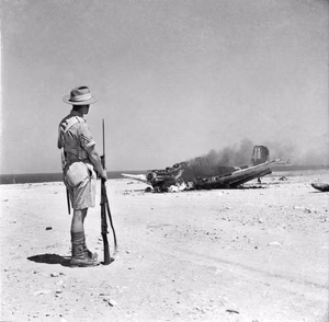 A crashed and burning German Junkers Ju 87B Stuka dive bomber near Tobruk, Libya, in 1941.