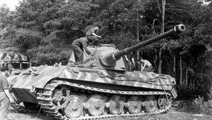 Frankreich.- Panzersoldaten auf Panzer VI "Tiger II" (Königstiger) am Waldrand beim Besprühen mit Farbe (?); PK KBZ Ob West — Frankreich
