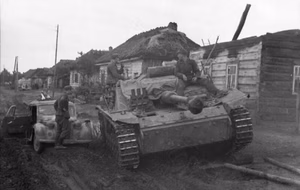 Rußland.- Sturmgeschütz III in Fahrt auf unbefestigter Straße durch ein Dorf; PK 670 — Russland
