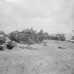 D-day - British Forces during the Invasion of Normandy 6 June 1944 Medics attending to wounded in the lee of a Churchill AVRE from 5th Assault Regiment, Royal Engineers, on Queen beach, Sword area, 6 June 1944. An M10 Wolverine 3-inch self-propelled gun from 20th Anti-Tank Regiment can be seen in the background.