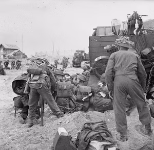 D-day - British Forces during the Invasion of Normandy 6 June 1944 Troops, including signallers and Beach Group personnel, sheltering behind a Universal Carrier on Queen beach, Sword Area, 6 June 1944.