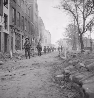 British troops walking through the devastated streets of Arnhem, 14 April 1945.