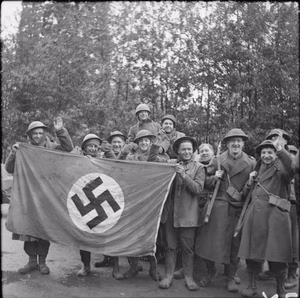 The British Army in North-west Europe 1944-45 Men of the 2nd Gordon Highlanders pose with a captured German swastika flag following the capture of Kleve, 11 February 1945.