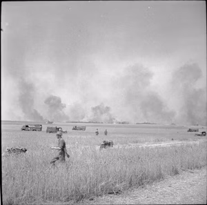 The British Army in Normandy 1944 Smoke rises in the distance after a raid on German positions at the start of Operation 'Totalise', 8 August 1944.