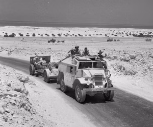 A CMP Field Artillery Tractor of the 9th Australian Division pulls a 25 pounder field gun up into position during the First Battle of El Alamein, 9 July 1942