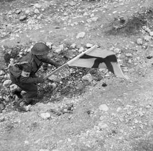 An RAMC medical orderly makes his way forward under cover of the Red Cross flag to recover a casualty during fighting at Cassino, 24 March 1944. The Medical Chain of Evacuation: An RAMC orderly makes his way forward under cover of the Red Cross flag to recover a casualty during fighting at Cassino.