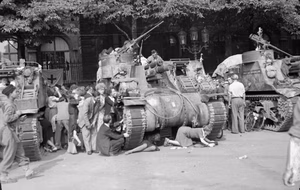 The Campaign in North-west Europe 1944-45 Civilians shelter behind Priest 105mm self-propelled guns of the French 2nd Armoured Division as German snipers open fire from buildings in Paris, 26 August 1944.