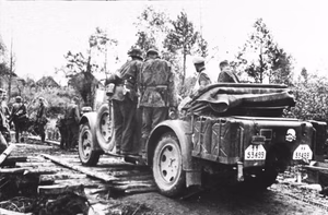 Sowjetunion-Nord.- Soldaten der Waffen-SS auf PKW bei Überquerung einer Behelfsbrücke / eines Knüppeldamms; SS-PK — Russland