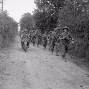 The British Army in the Normandy Campaign 1944 A motorcycle and infantry of the 2nd Glasgow Highlanders, 46th Brigade, 15th (Scottish) Division, during Operation 'Bluecoat', the offensive south-east of Caumont, 30 July 1944.