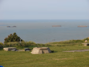 Remanescentes do porto artificial Mullberry, em Arromanches, vistos de cima das falésias a leste da vila, onde havia posição de radar alemã durante a segunda guerra. Em primeiro plano, um "Tobruck", um assentamento para metralhadora. Remnants of artificial port "Mullberry" in Arromanches, FR. View from the cliffs east of Arromanches, an old german radar site. Center view, one "Tobruck", a machine gun emplacement.