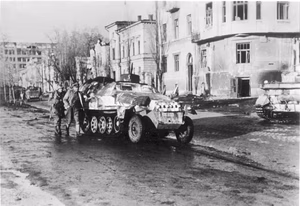 For documentary purposes the German Federal Archive often retained the original image captions , which may be erroneous, biased, obsolete or politically extreme . An der Sowjetfront: In den Straßen Charkows.- Charkow wurde am 14.3.43 von Verbänden der Waffen-SS zurückerobert. Im Schutze eines Schützenpanzerwagens geht der Regimentskommandeur einer SS-Panzer-Grenadier-Division Eichenlaubträger SS-Standartenführer Witt mit seinen Männern vor. PK-Aufnahme: Kriegsberichter Zschäkel, Scherl 1490-43 März 1943
