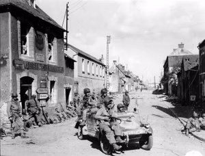 U.S. Airborne paratroopers in and on a captured VW Kübelwagen and by houses in Carentan, en:Battle of Normandy , 1944.