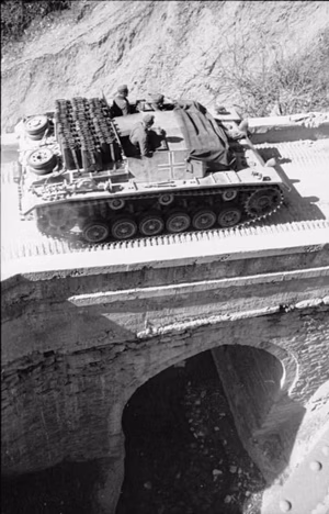 Balkan.- Sturmgeschütz III mit Kanistern auf dem Dach beim Überqueren einer Brücke; PK 690 — Balkan