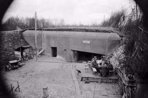 Im Westen.- Bunker an der Oberrheinfront an einem Fluss. deutsche Soldaten an Tisch vor Bunker sitzend; PK 670 — Im Westen