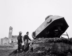 Original caption: "The remains of a German strongpoint [at Fano] comprising a turret and 75mm L/70 gun from a Panzerkampfwagen V (Panther tank) guarding the road to Rimini, after the Desert Harassers fighter bomber aircraft of the veteran No. 450 (Kittyhawk) Squadron RAAF had paid a call. Inspecting the bomb damage are 15728 Leading Aircraftman Harry Hogg Brown of Kiama, NSW (left), and 402100 Flight Lieutenant Douglas Lachlan Millar of Burwood, NSW."