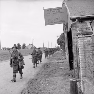 The British Army in the Normandy Campaign 1944 British troops pass the Hotel Restaurant Gondree at Benouville, near 'Pegasus Bridge' over the Caen Canal, 9 June 1944.