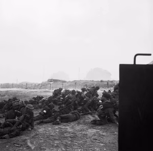 D-day - British Forces during the Invasion of Normandy 6 June 1944 Troops take cover while waiting to go forward on Queen beach, Sword Area, 6 June 1944. Part of the German strongpoint 'Cod' can be seen in the background.