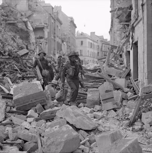 The British Army in Normandy 1944 Troops pick their way through the rubble of Caen, 9 July 1944.