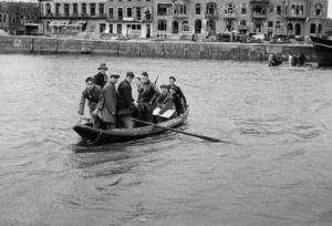 Civilians row an RAF reconnaissance officer back to his unit after carrying out an inspection of Middelburg in Holland, November 1944. An Officer returns to his R.A.F. reconnaissance squadron by ferry after carrying out an inspection of Middelburg. The crossing by water was made because of a bridge that was mined.