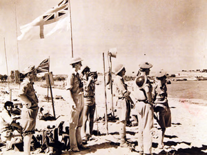 80-G-42797: Operation Husky, July-August 1943. British Army and Navy Officers and an American observer< Commander Walter Chappell, USNR, (standing left) liaison officer with the Eighth Army – watch landing parties pour in as they stand at a beach signal station, where the British flag has just been planted during the Sicilian Invasion, July 1943. Official U.S. Navy Photograph, now in the collections of the National Archives. (2017/08/01).