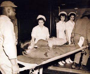 80-G-41775: Two hundred and four American patients, taken from USS West Point (AP 23) at Newport News, Virginia, on May 30th, 1943. They came from North Africa along with 2,944 captive Axis soldiers. A wounded soldier is being carried onto the hospital train. Photographed May 30, 1943. U.S. Navy Photograph, now in the collections of the National Archives. (2016/05/10).