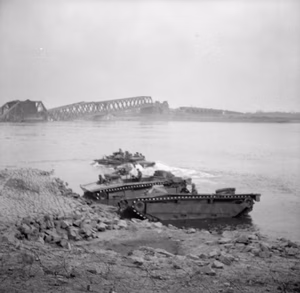 The British Army in North-west Europe 1944-45- Assault on the Rhine and Capture of Wesel This is one of a collection of pictures that show the landing from Buffaloes of the 1st Battalion Cheshire Regiment, who landed on the afternoon of 24th March 1945, in support of No.1 S.S Commando Brigade at Wesel. The bridge seen in background is the smashed railway bridge at Wesel.