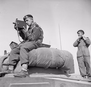 The Polish Army in the Normandy Campaign, 1944 Cameramen in uniform: 2nd Lieutenant Jerzy Januszajtis, a Polish Army Film Unit cameraman, films from the top of a Sherman tank of the 1st Polish Armoured Division tank during Operation 'Totalise', south of Caen, Normandy on 8 August 1944. He is using a De Vry camera fitted with a sling.