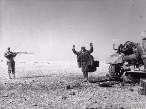 Indian troops capture one of the crew of a knocked-out German PzKpfw IV tank, 8 December 1941.