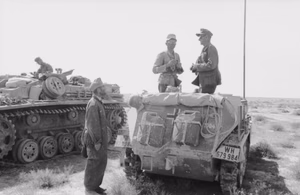 Nordafrika.- Zwei Soldaten in leichtem Schützenpanzer (Sd.Kfz. 250) mit Ferngläsern, im Gespräch, daneben Sturmgeschütz III; PK Afrika — Nordafrika