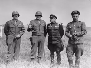 American and Soviet generals pose on the banks of the Elbe River near Torgau, Germany, where the two Allies linked up for the first time. Pictured from left to right are Brig. Gen. Charles G. Helmick (Commander of V Corps Artillery), Maj. Gen. Clarence R. Huebner (CG V Corps, First U.S. Army), Lt. Gen. Gleb Baklanov (Commanding General Soviet 34th Rifle Corps), and Maj. Gen. Vladimir Rusakov (Commanding General Soviet 58th Guards Rifle Division).