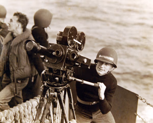 80-G-30315: Operation Torch, November 1942. Photography during the campaign. Shown: Photographer’s Mate 2/C William Wade, USN, trains his movie camera on a group of scout bombers. Official U.S. Navy Photograph, now in the collections of the National Archives. (2017/06/06).