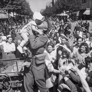 An AFPU photographer kisses a small child before cheering crowds in Paris, 26 August 1944. An AFPU photographer kisses a small child before cheering crowds in Paris, 26 August 1944.