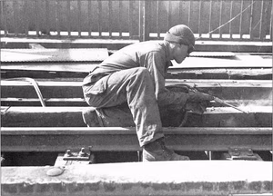 A welder from the 1058th Bridge Construction and Repair Group repairs the Ludendorff Bridge after it was captured on 7 March 1945.