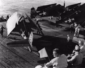 U.S. Navy Grumman F6F-5 Hellcat of Fighting Squadron 74 (VF-74) are being positioned and prepared for launching the invasion of Southern France from the decks of the escort carrier USS Kasaan Bay (CVE-69).