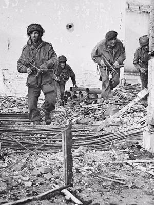 Four British paratroopers moving through a shell-damaged house in Oosterbeek to which they had retreated after being driven out of Arnhem Left to right Pvt Ronald Philip Walker Pvt John Dugdale 10pin C.co 156 Para L.Cpt Noel Rosenberg 10 pin C.co 156 Para Pvt Alfred J Ward HQ Para Brgd. Driver for Hackett