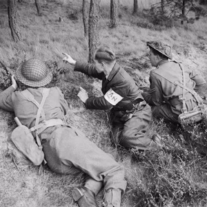 A member of the PAN (Partisan Action Netherlands) guides British troops to German positions near Valkenswaard, 25 September 1944. A member of the PAN (Partisan Action Netherland) helps British troops 'winkle out' stray Germans, near Valkenswaard, 25 September 1944.