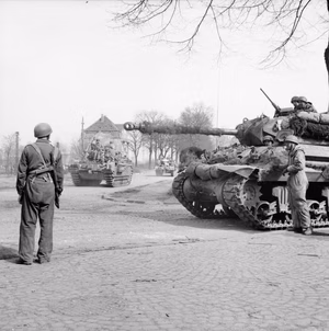 Churchill tanks of 6th Guards Tank Brigade carrying paratroopers from the American 17th Airborne Division pass through Dorsten in Germany, while an Achilles tank destroyer waits, 29 March 1945. Churchill tanks of 6th Guards Tank Brigade carrying paratroopers from the American 17th Airborne Division pass through Dorsten, 29 March 1945. On the right is an Achilles 17-pdr tank destroyer.