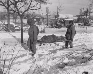 "Body of American soldier is borne on stretcher from terrain in vicinity of Malmedy, Belgium, where on or about 17 Decem NARA 532956