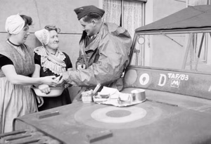 An RAF sergeant shares an alfresco lunch with two Dutch women at Nieuland, near Middelburg, soon after the town had been liberated by Allied forces, November 1944. An R.A.F. sergeant shares an alfresco lunch with two Dutch women at Nieuland, near Middelburg, soon after the town had been freed by the Allied.