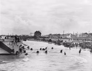 Follow-up waves of the 9th Canadian Infantry Brigade disembarking with bicycles from landing craft onto 'Nan White' sector of Juno Beach at Bernieres-sur-Mer, 6 June 1944. The British 2nd Army: second-wave troops of 9th Canadian Infantry Brigade, probably Highland Light Infantry of Canada, disembarking with bicycles from LCI(L)s (Landing Craft Infantry Large) onto 'Nan White' Beach, JUNO Area at Bernieres-sur-Mer, shortly before midday on 6 June.
