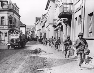 Troops of the 47th Infantry Regiment, attached to the 9th Infantry Division, march through Remagen to cross the Ludendorff Bridge on March 9, 1945. They were assigned to a task force of Combat Command B of the 9th Armored Division, consisting in part of the 47th Infantry Regiment, 27th Armored Infantry Battalion and the 14th Armored Battalion.