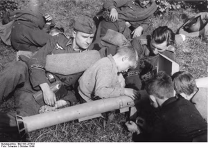 For documentary purposes the German Federal Archive often retained the original image captions , which may be erroneous, biased, obsolete or politically extreme . Während einer kurzen Ruhepause, die die Grenadiere der Ersatzbrigade "Grossdeutschland" im Verlaufe einer Felddienstübung einlegten, benutzte die wissbegierige Dorfjugend die Gelegenheit, sich einmal alles "ganz genau" anzusehen.- Hier betrachten die Jungen interessiert den "Panzerschreck", die gefürchtete deutsche Panzernahbekämpfungs-Waffe [Raketen-Panzer-Büchse]. Scherl-Bilderdienst (Schwahn) 10.10.44