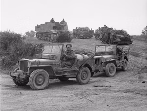 The British Army in Normandy 1944 — U.S. made jeeps leading a column with carriers and a Sexton 25-pdr self-propelled gun, moving forward south of Caen, 1 August 1944. — Likely from the U.K. Army Film and Photographic Unit