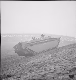 The British Army in North-west Europe 1944-45 A Buffalo of 79th Armoured Division on the banks of the River Ijssel at Arnhem, with the blown railway bridge in the background, 13 April 1945.