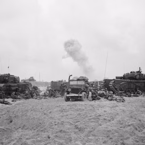 D-day - British Forces during the Invasion of Normandy, 6th June 1944 Churchill AVREs of 5th Assault Regiment, Royal Engineers, carriers and a jeep on Sword Beach. Wounded are being treated by the side of the vehicles.