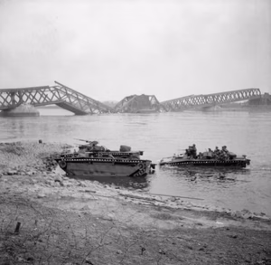 The British Army in North-west Europe 1944-45- Assault on the Rhine and Capture of Wesel This is one of a collection of pictures that show the landing from Buffaloes of the 1st Battalion Cheshire Regiment, who landed on the afternoon of 24th March 1945, in support of No.1 S.S Commando Brigade at Wesel. The bridge seen in background is the smashed railway bridge at Wesel.